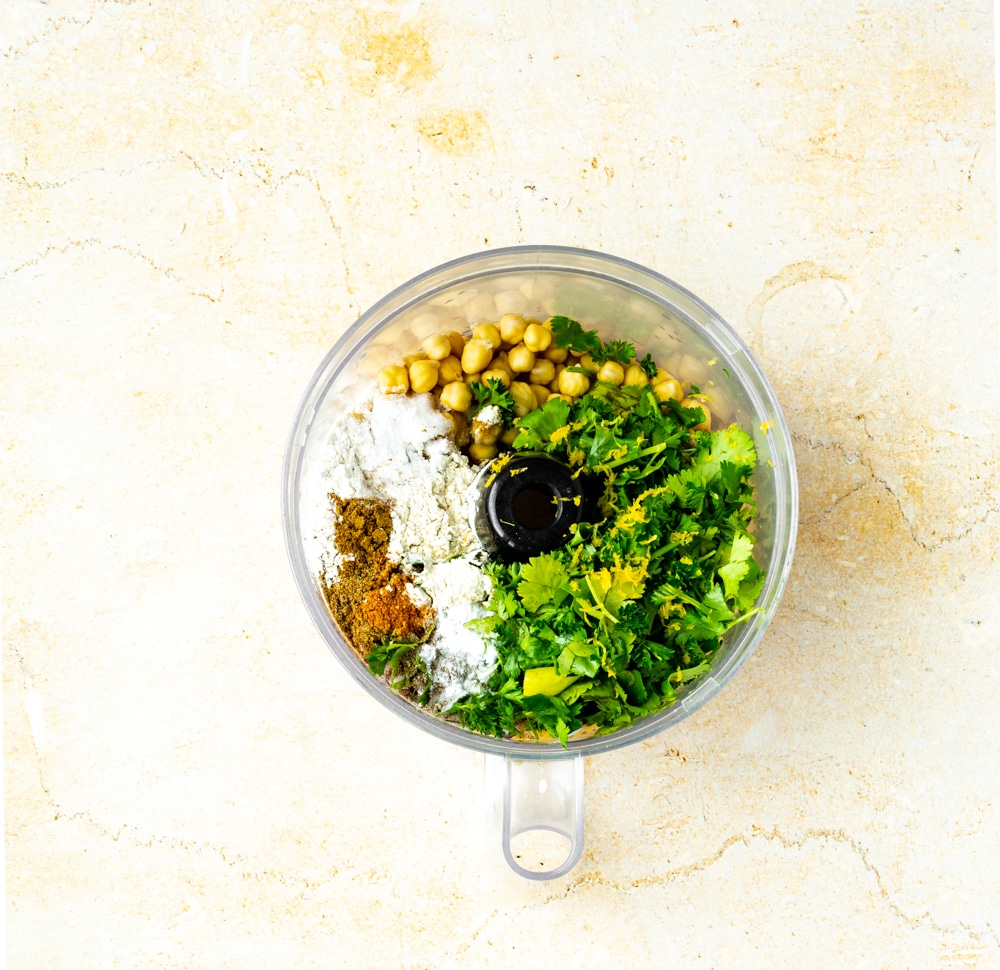 chickpeas parsley, cilantro, flour, cayenne, lemon zest, ground cardamom, ground cumin, onions, garlic, salt, pepper, baking soda, in food processor