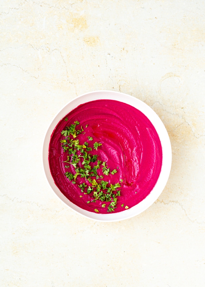 roasted beet hummus with chopped parsley in bowl