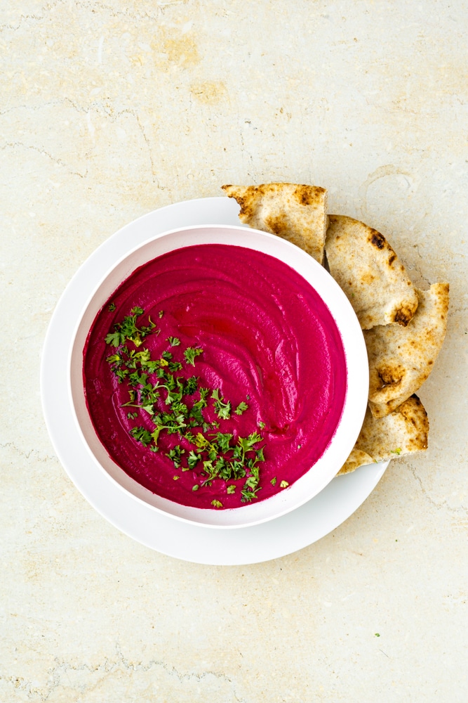 roasted beet hummus with chopped parsley in bowl